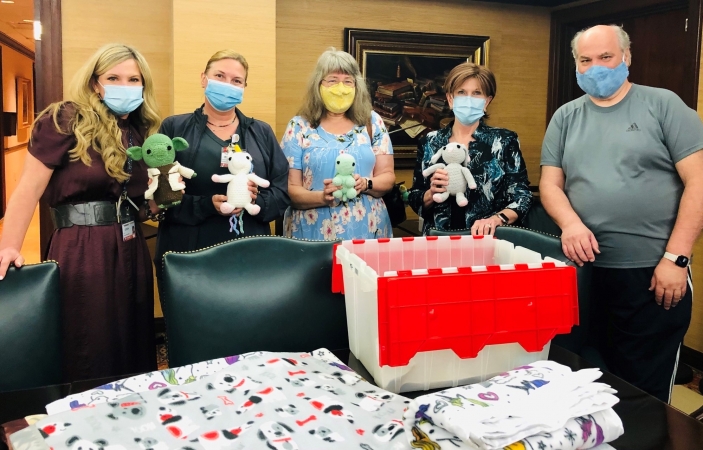 From Left: Lecia Bowman, chief nursing officer; Robin Davis, clinical/operational manager for pediatrics; Janet Kats; Vicki Briggs, CEO; and Greg Kats display some of the handmade creations that were donated to the hospital Wednesday. 