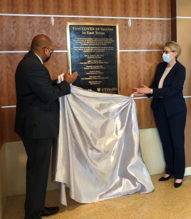 Dr. Kirk A. Calhoun, Chairman of the Board of UT Health East Texas and President of The University of Texas at Tyler, and Dr. Julie Philley, Executive Vice President of Health Affairs at The University of Texas Health Science Center at Tyler, unveil the plaque commemorating the one-year anniversary of the first COVID-19 vaccine given in East Texas