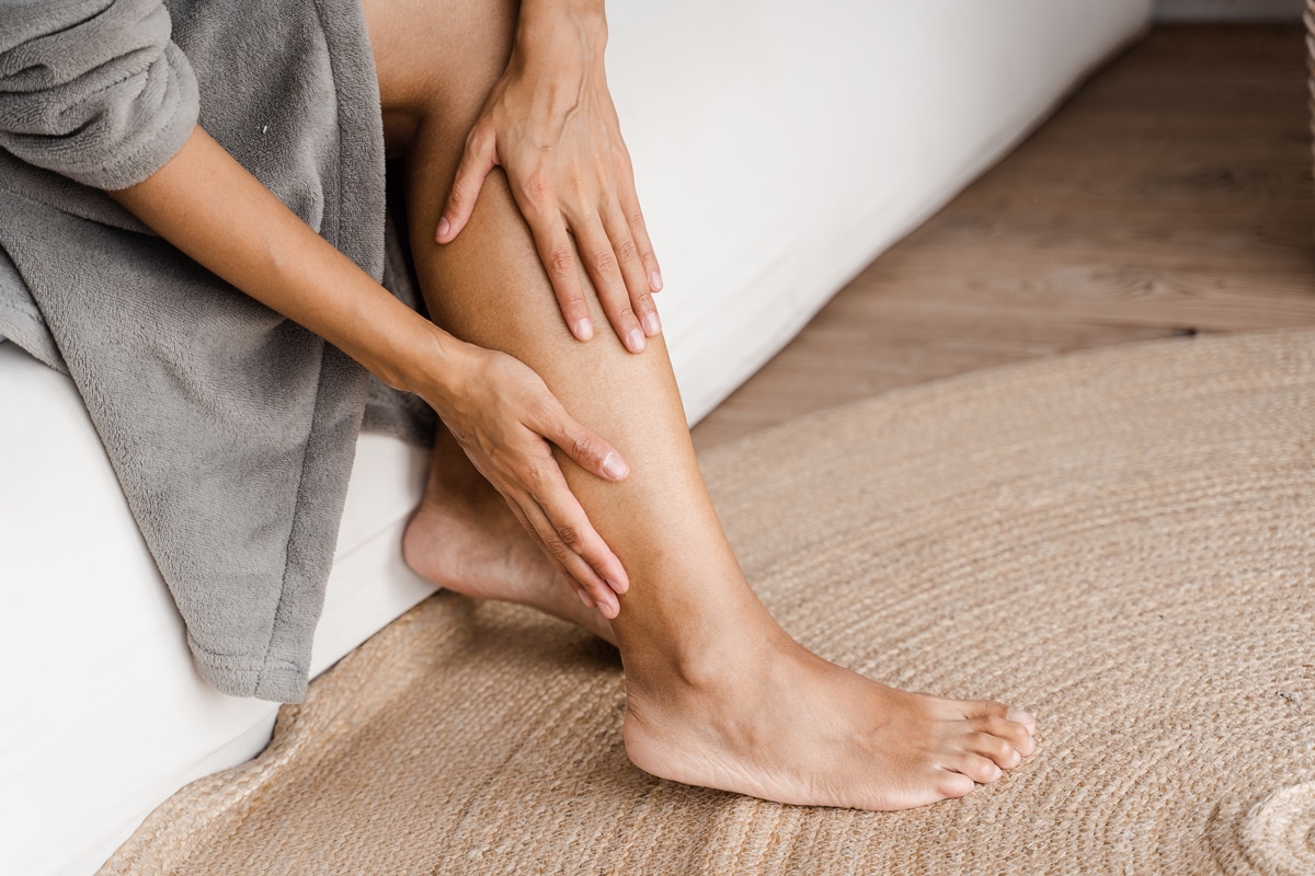 woman rubbing her lower leg