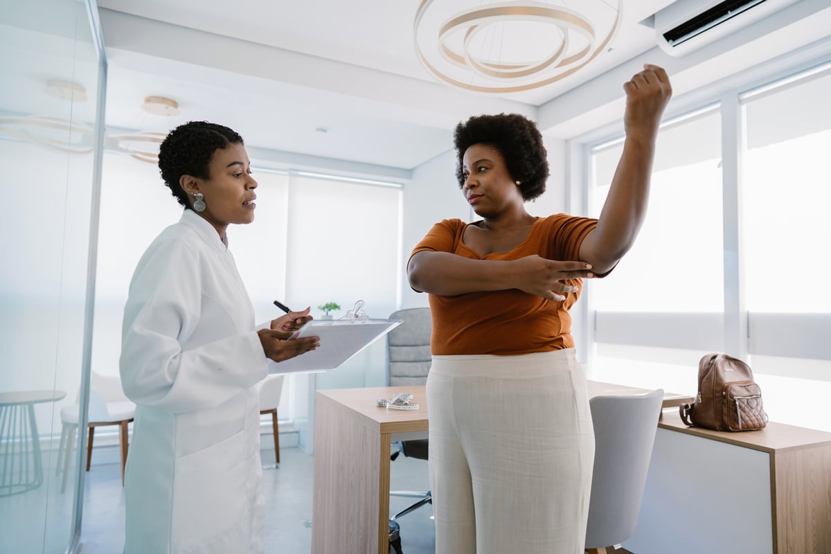 Woman holding her arm up in front of her doctor