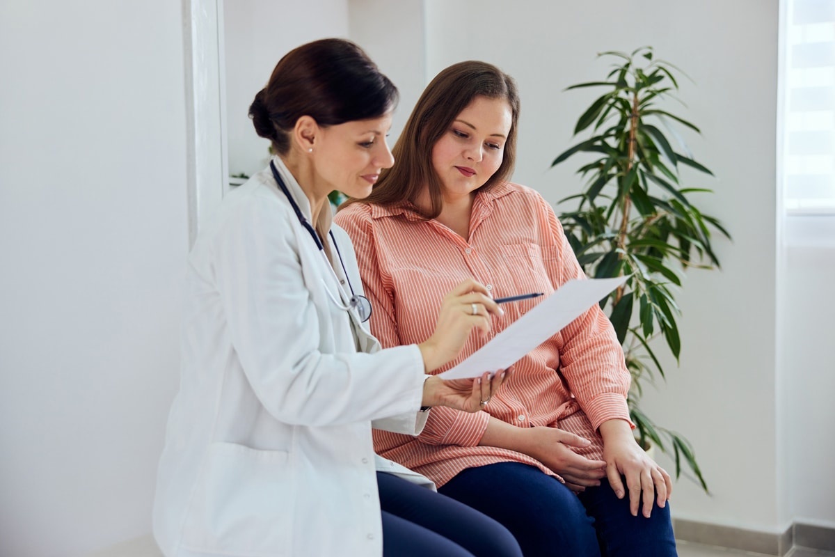 Doctor showing her patient something n a clipboard