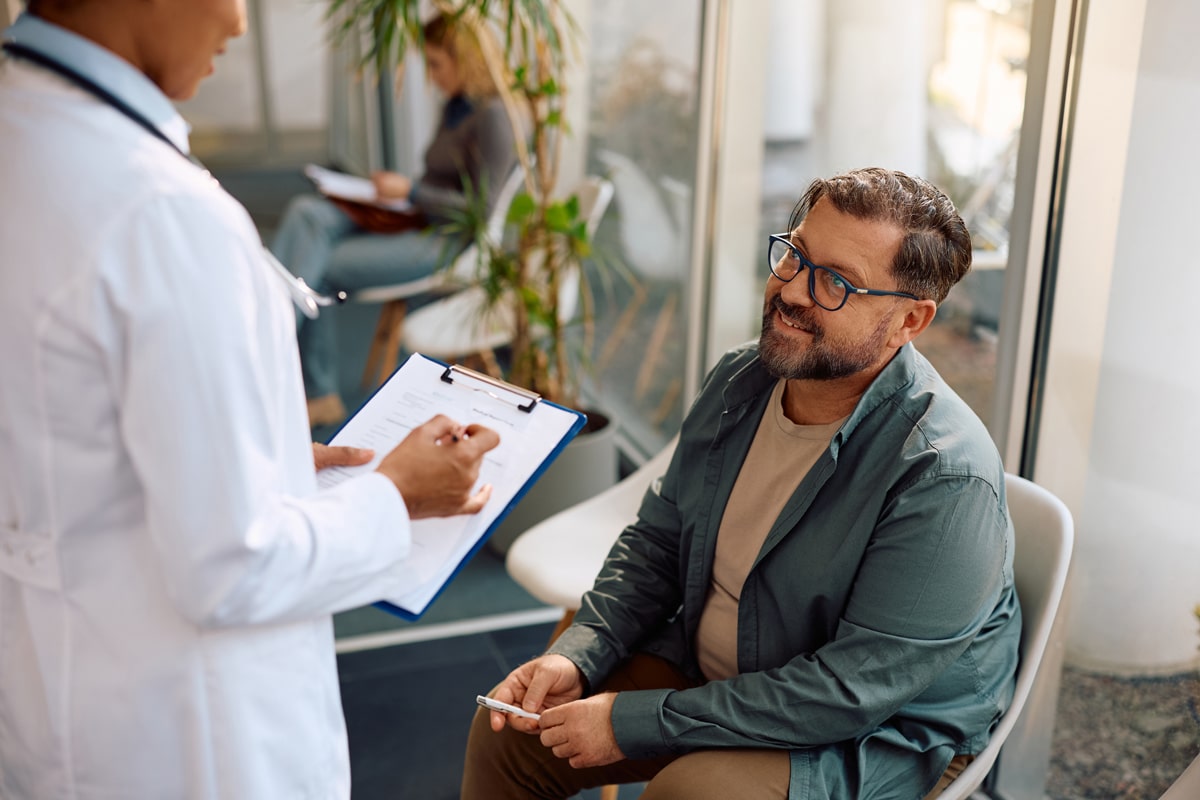 Doctor with clipboard talking to a patient