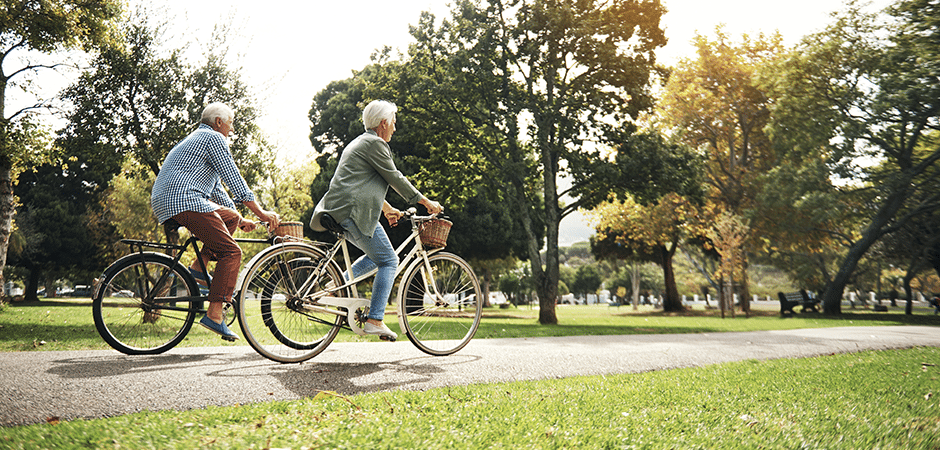 elderly couple riding bikes together